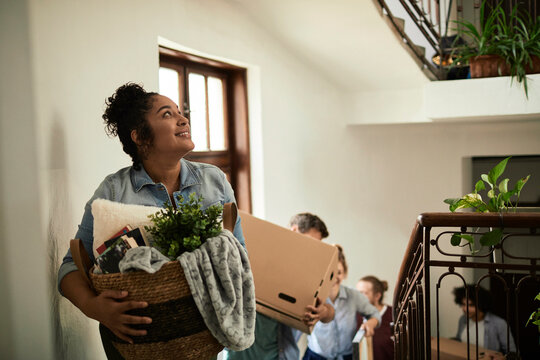Group of people moving house with boxes and plants