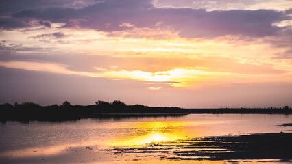 Lever du soleil et reflets sur l'eau d'une plage en camargue (près de Salin de Giraud)