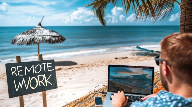 Remote work concept image with a man working from the beach on his laptop computer and sign with written words "REMOTE WORK".