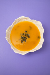 Pumpkin and spinach soup in white bowl