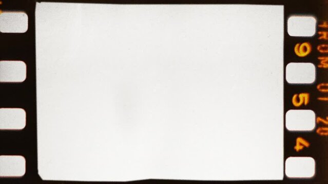 A film frame with orange letters on the perforation 