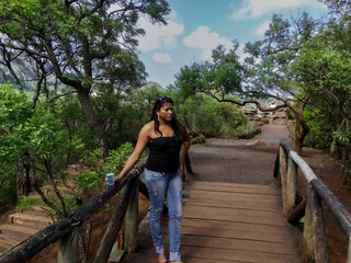 Woman crossing a beautiful wooden bridge, with lots of vegetation around, in Mangabeiras Park, Belo Horizonte, Minas Gerais.