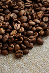 Fototapeta premium coffee beans are on table after roasting. Fresh converted coffee beans before packing in paper bag. Ground coffee for making Americano or cappuccino. grain cultivation and harvesting