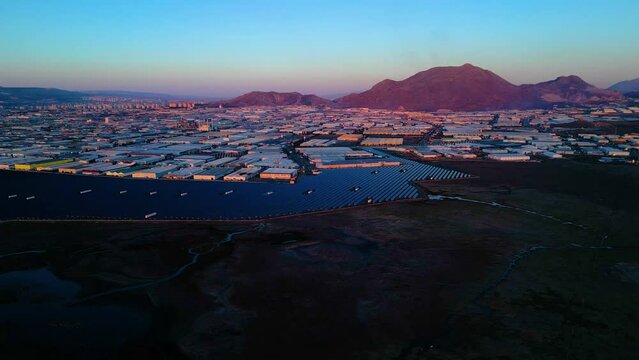 Evening aerial view of factories and a giant solar energy field