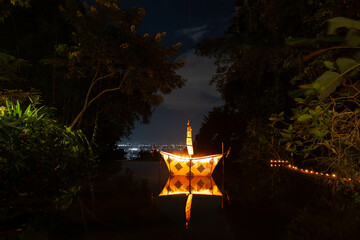 Paper boat on the river with candles at night during Loy Krathong festival. Wat Pha Lat temple near...