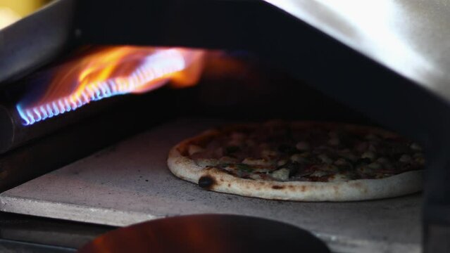 Pizza is baked in the oven near the burning.