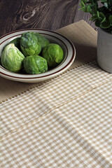 Fresh Brussels sprouts in a bowl, ready to cook. Space for text.