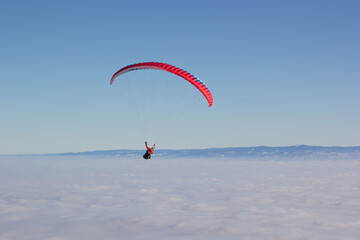 Paragliding. Paragliding in Auvergne. paragliding flight in the mountains in France. Paragliding over the clouds. Sea of clouds and paraglider. Panorama of the mountains. Puy de Dôme