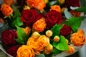 Vibrant Red and Orange Rose Bouquet With Green Leaves