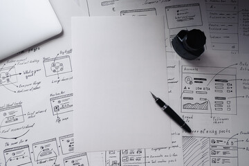 Blueprints, laptop and blank sheet of paper on background with product wireframes. Design layout, creative ideas and workspace