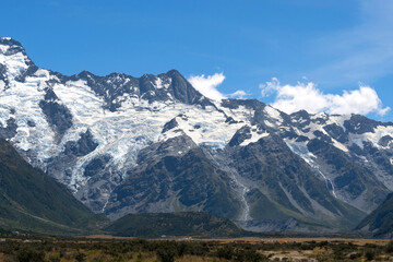 The massive mountains with glacier in a peaceful summer day with fresh blue sky at Mount Cook National Park, New Zealand.