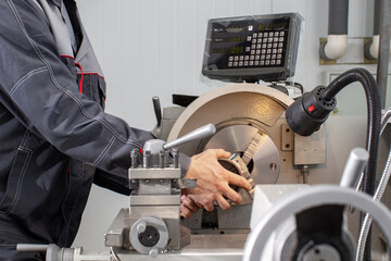 A worker works on a lathe at a machine-building plant.