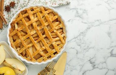 Tasty homemade quince pie served on white marble table, flat lay. Space for text