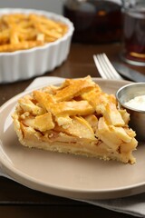 Piece of tasty homemade quince pie with ice cream on wooden table, closeup