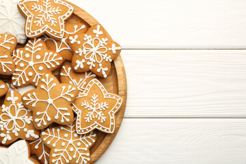 Tasty Christmas cookies with icing on white wooden table, top view. Space for text