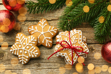 Tasty Christmas cookies with icing and festive decor on wooden table, flat lay