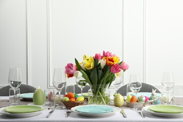 Easter celebration. Festive table setting with beautiful flowers and painted eggs