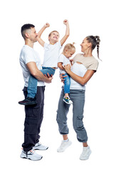 Happy family with children. Mom, dad, daughter and son in white T-shirts and jeans hug and laugh. Love and tenderness. Full height. Isolated on a white background. Vertical.