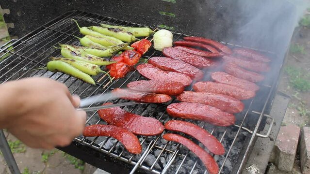 delicious grilled sausage cooked on the barbecue. tomatoes and peppers.