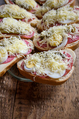 wrapped sandwich in a bowl, ham, cheese, cucumber, eggs on a wooden background