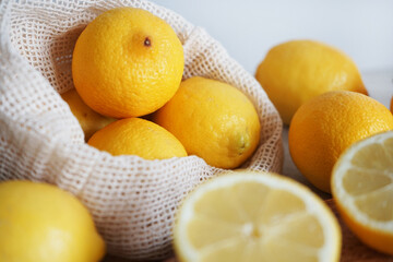 Whole and sliced ​​lemons on a wooden board on a light background