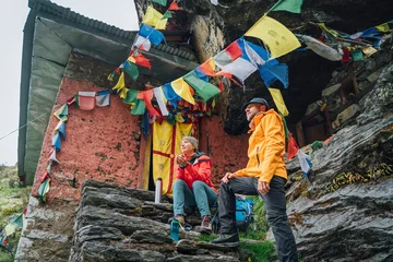 Peel and stick wall murals Makalu Resting Backpackers Couple tea break at small sacred Buddhist monastery decorated multicolored Tibetan prayer flags with mantras. Climbing Mera Peak route in Makalu Barun National Park, Nepal