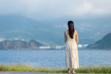 Asian woman wear dress and look at the sea