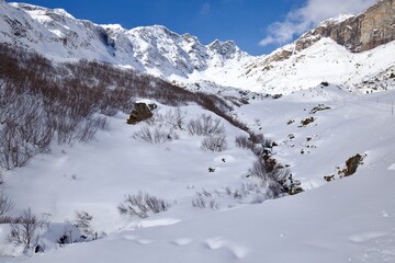 Paesaggio alpino con neve, torrente giornata di sole