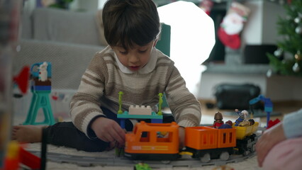 Creative Playtime - Kids Engrossed in Building Railroad Track and Train Set on Living Room Floor, Siblings Sharing Fun and Learning Experience