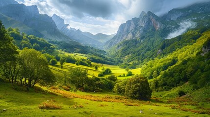 Fototapeta na wymiar Majestic view of beautiful lush green valley with trees and colorful grass against picturesque high mountains in asturias in spain