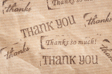 Ink stamp of Thank you messages on kraft paper. Full frame - obrazy, fototapety, plakaty