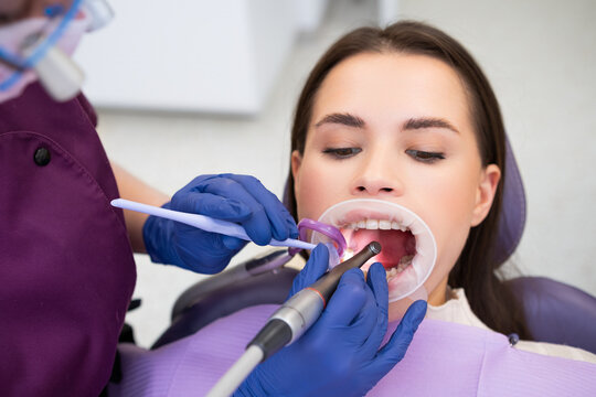 Caries treatment provided for a young woman in a modern dentist clinic