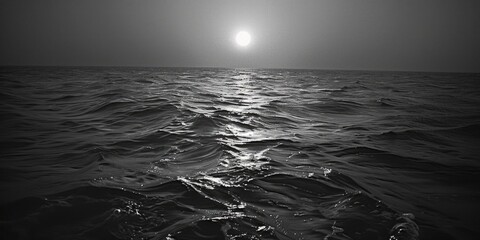 Stunning black and white photo of the sun shining over the ocean. Perfect for various design...