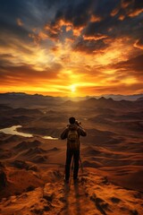 A man capturing a stunning sunrise over a desert landscape, his camera poised to immortalize the moment