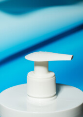 Fototapeta na wymiar Liquid soap dispenser close-up on a blue background. Liquid dispenser. Background for purity. Hygiene and science.