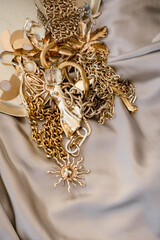 Lots of golden luxury jewelry on a golden background. Pawnshop or jewelry trade concept