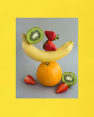 Pyramid of fruit and berry in balance on the gray and yellow background. Close-up.