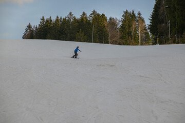 a snowboarder in a blue sweatshirt and helmet rides on a snowy slope