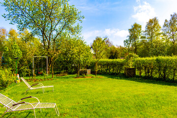 Garden with trees plants hut compost beds lawn in Germany.
