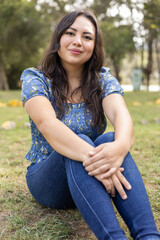 Obraz premium rest in the middle of nature, young latin woman with casual clothes on a sunny day, healthy lifestyle and well-being of person, beautiful park