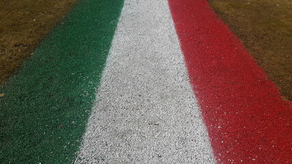 big red white green Italian flag drawn with paint on the street