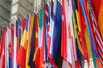colorful flags of many world states hanging during the international convention without people