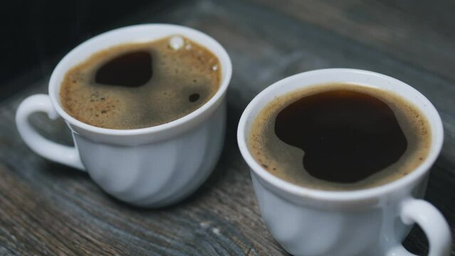 Two small cups of hot freshly brewed black coffee. Close up.