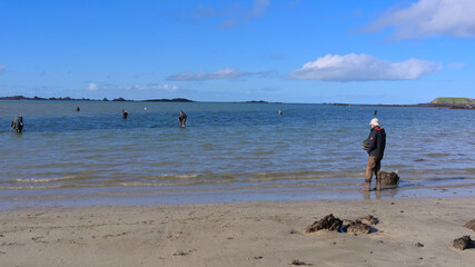 People fishing during low tide on the beach of Lancieux