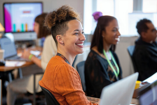 Candid capture of an engaged African American non-binary person during a business training session, highlighting DEI in the workplace.

