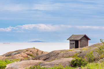 Fototapeta na wymiar Ostseeküste mit Felsen und Holzhütte bei Oskashamn in Schweden