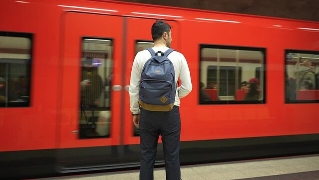 Footage of a man with a backpack waiting on the platform at a Helsinki Metro station as the train arrives. Ideal for urban lifestyle, travel, and public transport themes.