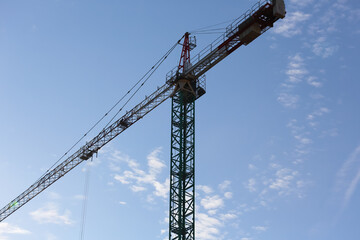 Tall tower crane against blue sky
