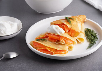 Pancakes with salmon, sour cream and greenstuff. Thin, not sweet blinchiki stuffed with red fish. Feast of Maslenitsa
