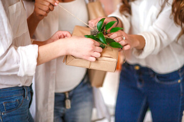 Gifts wrapped in kraft paper in the hands of guests at the Baby shower party